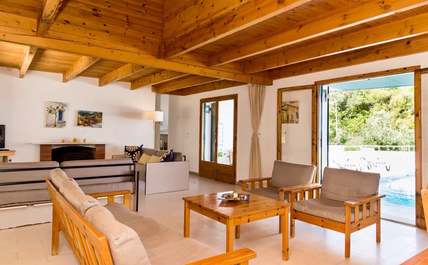 Spacious lounge with wooden beams and pool views at women's wellness retreat in Zakynthos