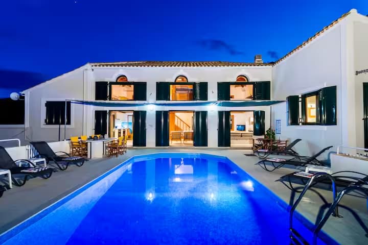 Women's wellness retreat villa exterior with pool illuminated at night in Zakynthos, Greece